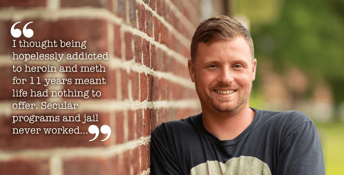 An RU overcomer beside a brick wall, recalling eleven years of heroin and meth addiction and the hopelessness he felt